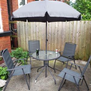 een tafel met twee stoelen en een parasol bij Monarch House in Manchester