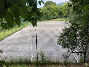 a tennis court behind a chain link fence at Bryn Melyn Farm Cottages in Bala