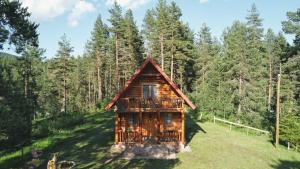 eine Blockhütte im Wald mit einer Terrasse in der Unterkunft Holiday home Aster in Žabljak