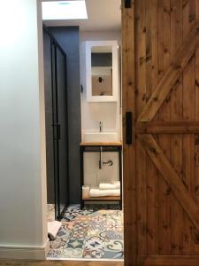 a bathroom with a wooden door and a sink at Apartament Ko-Piernika w Toruniu, w Sercu toruńskiej Starówki in Toruń +39 photos