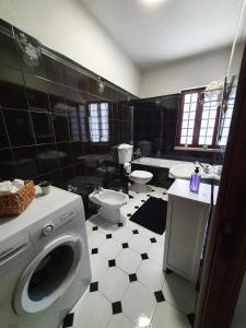 a black and white bathroom with a washing machine at Casa do Cruzeiro in Aguiar da Beira