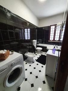 a black and white bathroom with a washing machine at Casa do Cruzeiro in Aguiar da Beira +8 photos