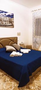 Un dormitorio con una cama azul con toallas. en B&B VENTO DEL SUD, en Palermo