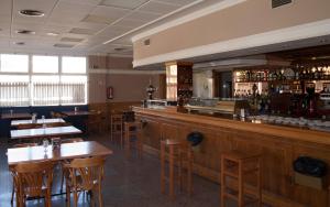 a restaurant with a bar with wooden tables and chairs at Hotel Azuqueca in Azuqueca de Henares