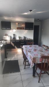 a dining room with a table and a kitchen with a counter at ACONCHEGO DE CANELA/RS in Canela