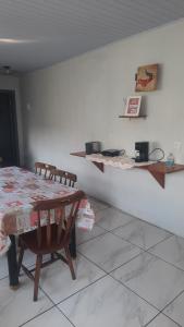 a dining room with a table and chairs in a room at ACONCHEGO DE CANELA/RS in Canela
