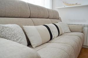 a brown couch with a black and white blanket on it at Viento Norte - Amplia terraza y chill out para quienes buscan descanso y calidez in San Vicente de la Barquera