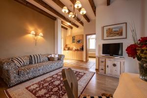 a living room with a couch and a tv at Hotel Finkennest - Panoramic Garden Resort in Schenna