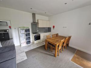 - une cuisine avec une table et des chaises en bois dans l'établissement Milne Apartment 2, à Milnrow