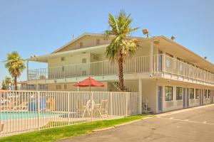 een huis met een zwembad en een palmboom bij Motel 6-Fresno, CA - Blackstone North in Fresno