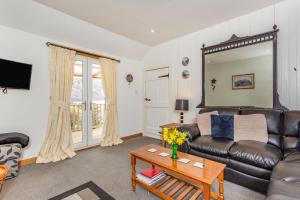 a living room with a leather couch and a table at Druidaig Cottage in Letterfearn