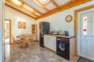 uma cozinha e sala de jantar com máquina de lavar e secar roupa em Druidaig Cottage em Letterfearn