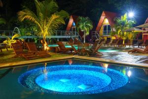 a pool at night with chairs and a resort at Greengos Hotel in Lanquín