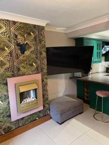 a living room with a fireplace and a tv at Flosh Cottage Lake District in Cleator