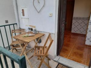 een kleine tafel en stoelen op een balkon bij Casa das Neves in Manteigas