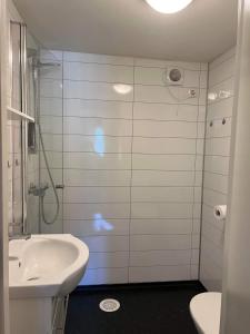 baño blanco con ducha y lavamanos en FeelHome small 1 bedroom apartment Polar vegen, en Tromsø