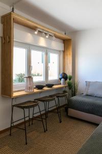 um quarto com uma cama e uma secretária ao lado de uma janela em Vista espectacular playa de Supertubos, Peniche em Atouguia da Baleia