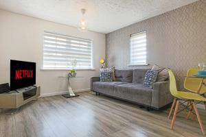 a living room with a couch and a tv at Delightful 2 BED APARTMENT for BICESTER OUTLET SHOPPING by Platinum Key Properties in Bicester