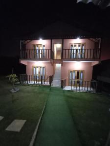 ein Haus in der Nacht mit grünem Rasen davor in der Unterkunft SERRA DA NEBLINA in Lavras Novas
