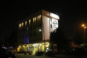 a building with cars parked in front of it at night at Rozana Hotel in Amman