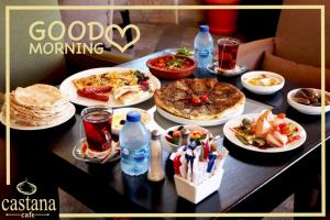 a table topped with plates of food and drinks at Rozana Hotel in Amman