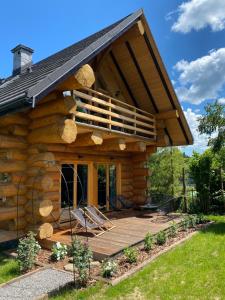 a log cabin with a porch and a deck at Jedlina - naturalny dom z bali jodłowych in Cisna