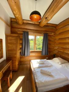 a bedroom with a bed in a wooden house at Jedlina - naturalny dom z bali jodłowych in Cisna
