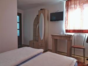 a bedroom with two beds and a mirror and a chair at LA GRADINA 