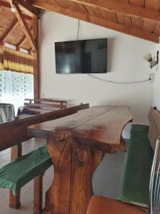 a dining room with a wooden table and a flat screen tv at LA GRADINA 