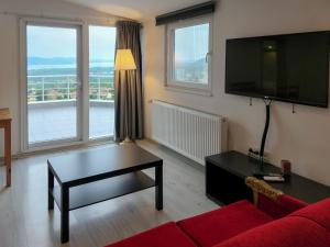 een woonkamer met een rode bank en een flatscreen-tv bij Yaylı Apart in Masukiye