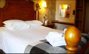 a hotel room with a bed with towels on it at Ban-Car Hotel in Cairness