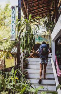 a person walking up some stairs with a backpack at Mahalo Hostel in Abraão