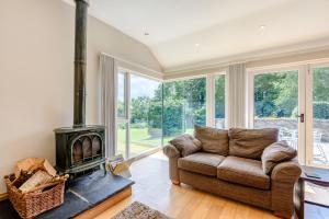 a living room with a couch and a wood stove at Bwthyn Gwyn in Llanfairpwllgwyngyll