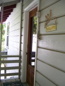 uma porta para uma casa com um sinal de boas-vindas em The Treehouse em St. Petersburg