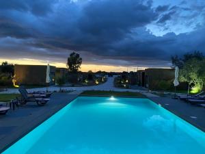 a swimming pool in a resort with a sunset at EcoVillas Escudeira in Reguengos de Monsaraz