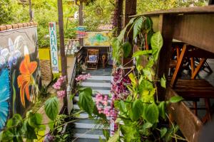 a walkway with plants and a bench in a garden at Mahalo Hostel in Abraão