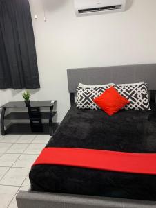 1 dormitorio con cama negra y almohadas rojas en CHILL SPOT, en Ceiba