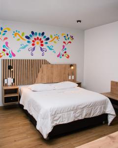 a bedroom with a bed with a flower mural on the wall at Platero Hotel in Ayacucho