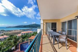 a balcony with a table and chairs and a view of the ocean at Casa Oceana - Airlie Beach in Airlie Beach