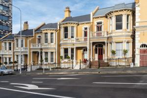 una fila di case gialle su una strada cittadina di Luxury Apartment on Stuart a Dunedin