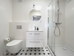 a white bathroom with a toilet and a shower at Vincent Apartamenty Darłówek in Darłowo