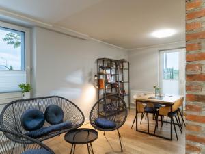 a living room with chairs and a table and a desk at Vincent Apartamenty Darłówek in Darłowo