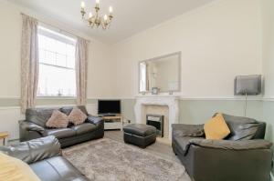 a living room with leather furniture and a fireplace at Roseberry House in Guisborough