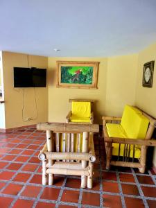 a room with two chairs and a table and a television at Finca Hacienda el Castillo Santa Fe de Antioquia in Santa Fe de Antioquia
