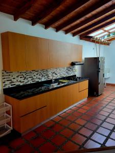 cocina con armarios de madera y nevera de acero inoxidable en Finca Hacienda el Castillo Santa Fe de Antioquia, en Santa Fe de Antioquia