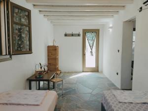 Habitación con 2 camas, mesa y ventana en Melia Sifnos House en Platis Yialos Sifnos