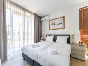 een slaapkamer met een groot bed en een groot raam bij Holiday Home in Harderwijk with Private Outdoor Jacuzzi in Harderwijk