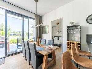 una sala da pranzo e un soggiorno con tavolo e sedie. di Holiday Home in Harderwijk with Private Outdoor Jacuzzi a Harderwijk