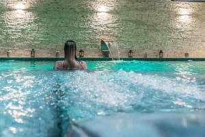 a woman is in a swimming pool at VH Eurostar Tirana Hotel Congress & Tirana Spa in Tirana