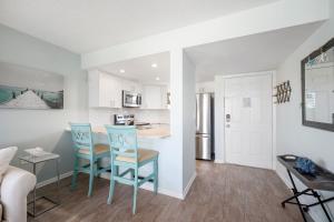 a kitchen and living room with blue chairs and a table at Ocean Village Club D23 in Saint Augustine
